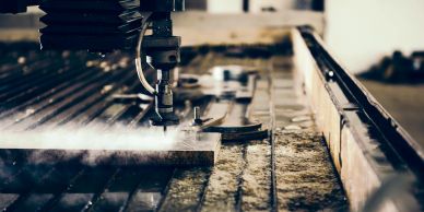 Industrial waterjet cutting a metal sheet with precision.