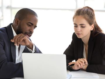Male and female sitting looking at a computer