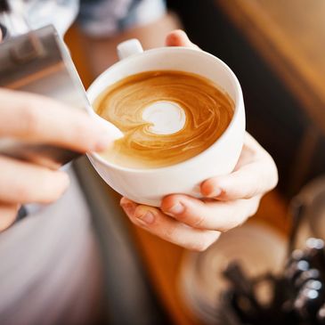 Barista making a pattern on a coffee