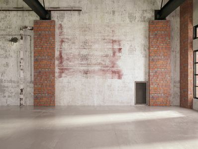 Empty industrial loft with exposed brick and concrete walls.