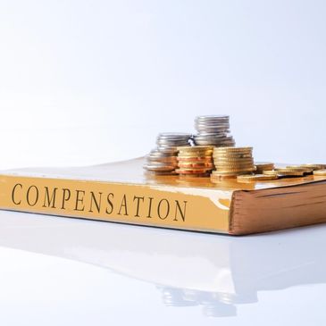 Compensation law book with coins symbolizing accident claims payout