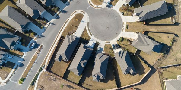 Aerial view of a suburban cul-de-sac with houses and driveways.