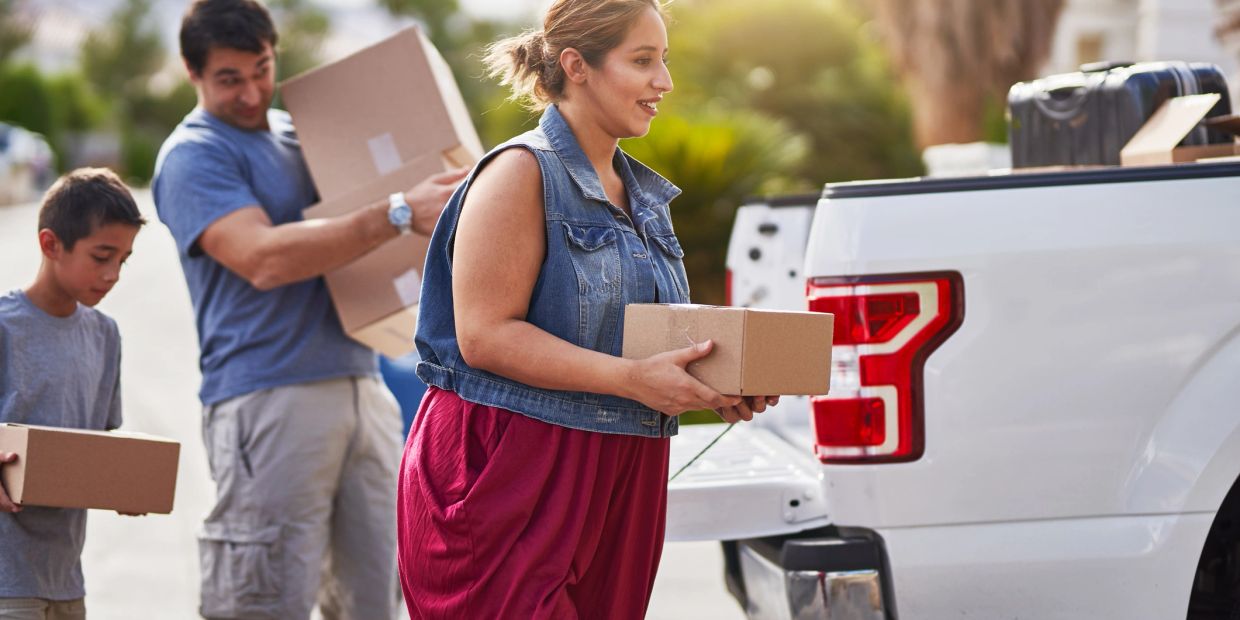 Family loading boxes into a pickup truck.