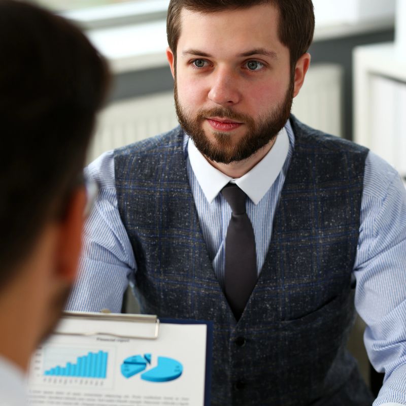 Group of businessmen with financial graph and silver pen in arm solve and discuss problem with colleague portrait. Situation examination at board council sale adviser job stock exchange market profit