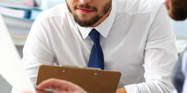 Businessman in white shirt and blue tie attentively listening.