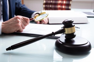 Judge with gavel and magnifying glass.