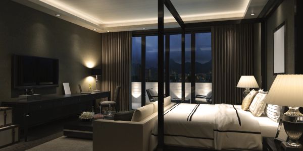 Modern, dimly lit bedroom with balcony at night.