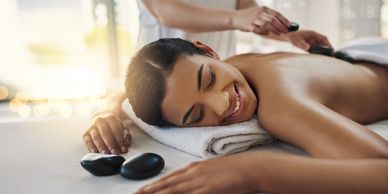 Woman enjoying a relaxing hot stone massage at a spa.
