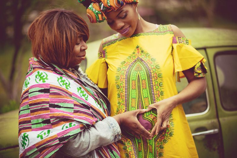 Only give love. African American pregnant woman in the park with her mother.