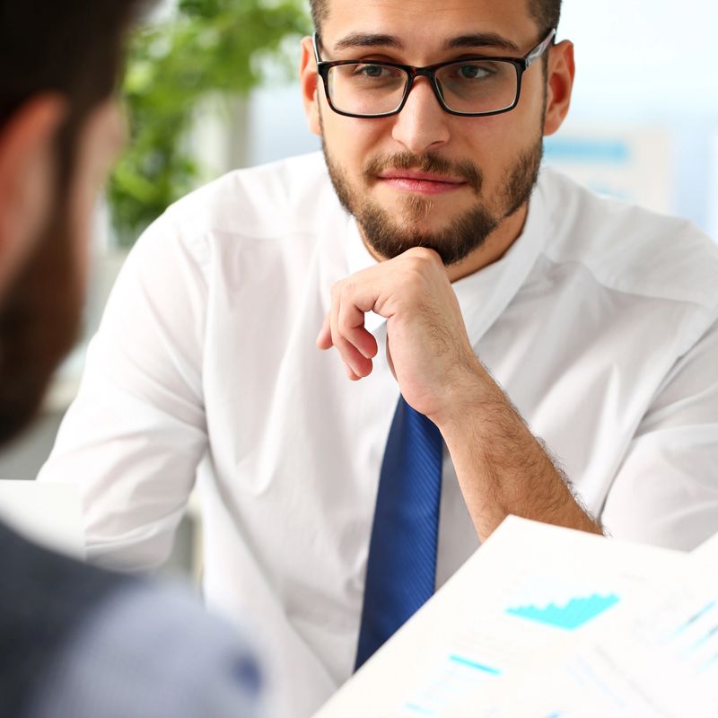 Group of businessmen with financial graph and silver pen in arm solve and discuss problem with colleague portrait. Situation examination at board council sale adviser job stock exchange market profit