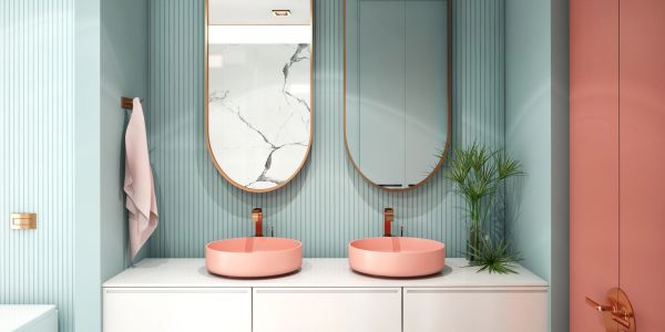 Modern bathroom with pink sinks and oval mirrors.