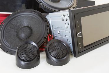 Car audio system components including speakers and a touchscreen head unit.
