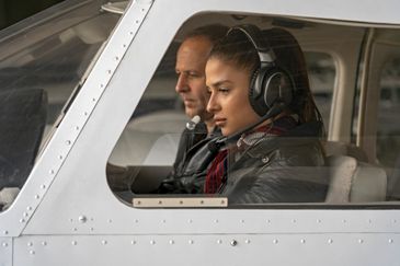 Two people focused inside a small airplane cockpit.