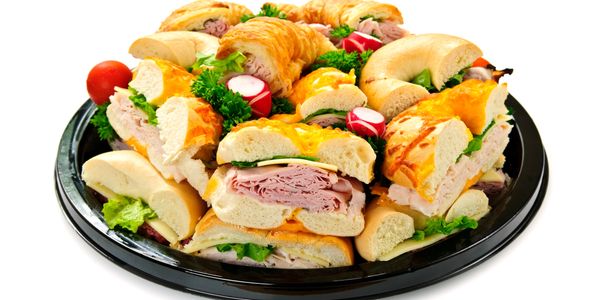 Platter of assorted sandwiches with cold cuts and veggies.