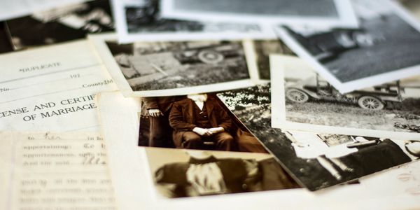 A collection of vintage black and white photographs and a marriage certificate.