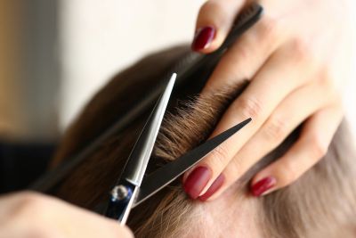 Close-up of a haircut with scissors and comb.