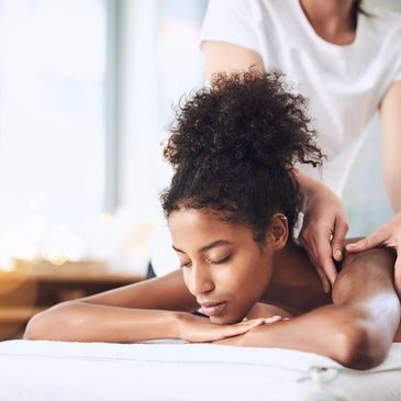 Woman enjoying a relaxing shoulder massage in a serene spa setting.