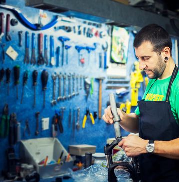 Man repairing a bike in a workshop.