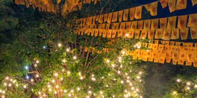 String lights and decorative flags hanging in a nighttime outdoor setting.