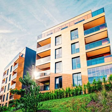 Modern apartment building with balconies and greenery.