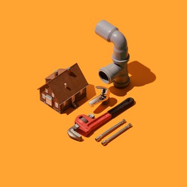 Plumbing tools and a miniature house on an orange background.