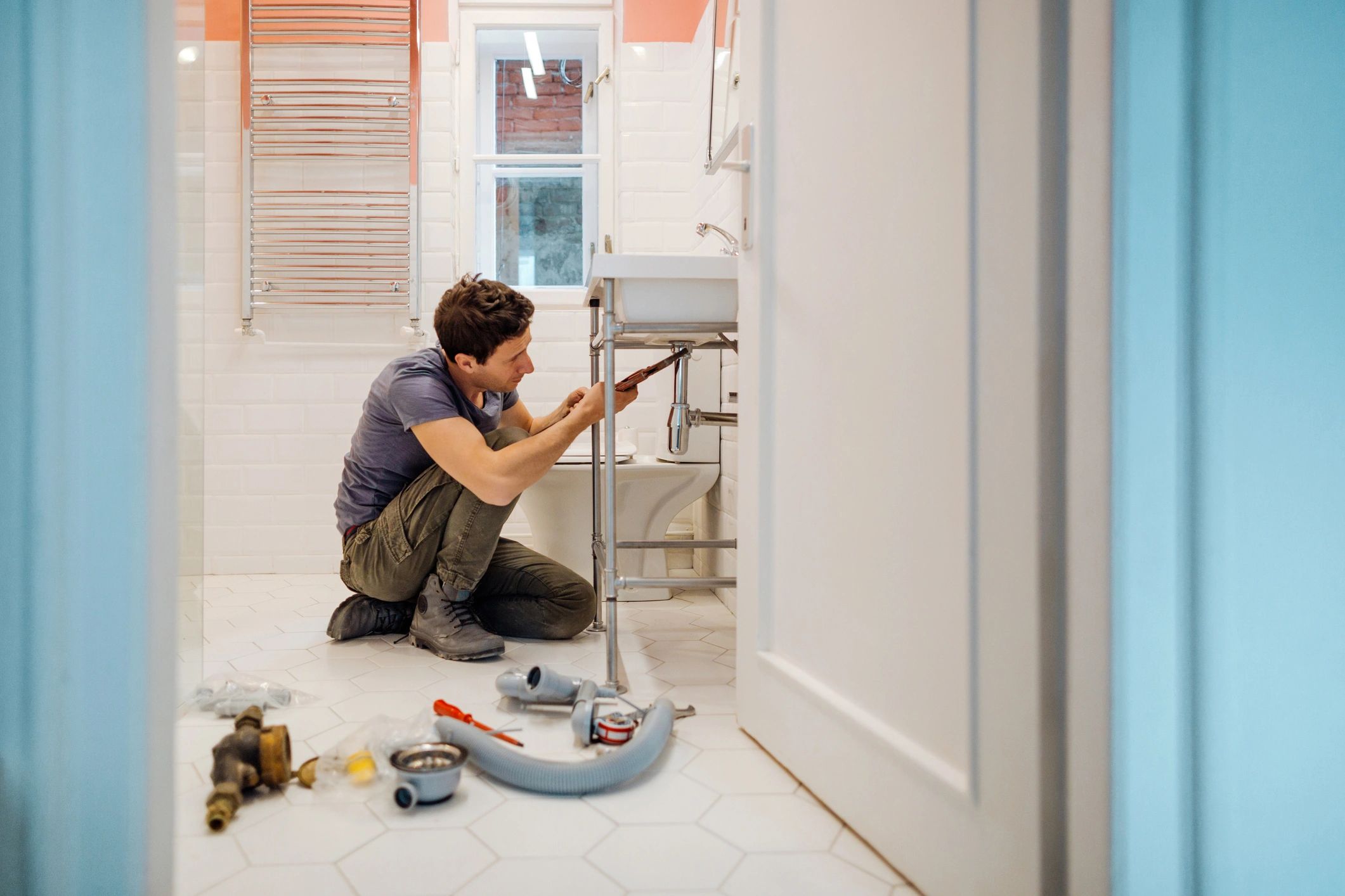 Man fixing bathroom plumbing.