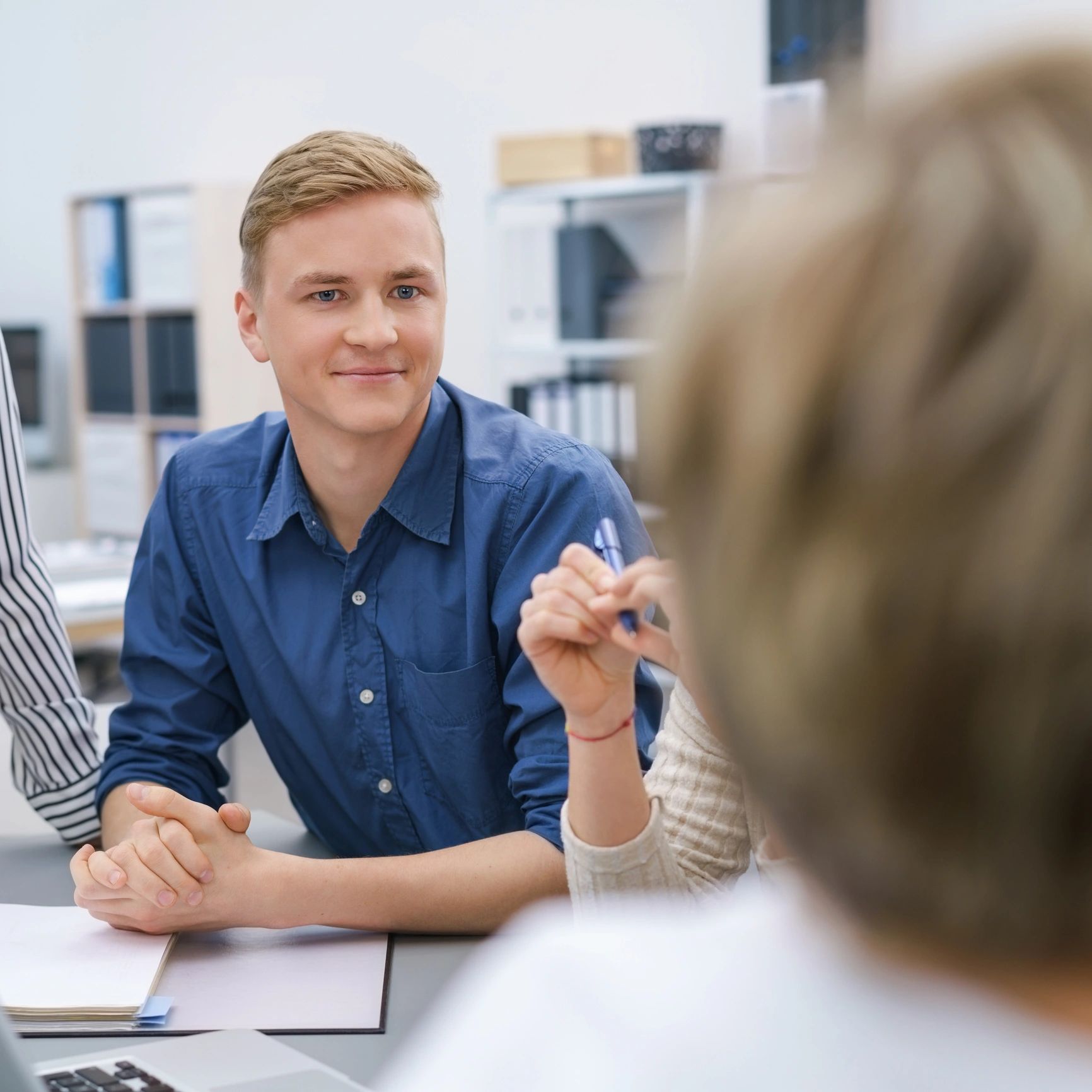 Young man attentively listening during a meeting in a modern office.