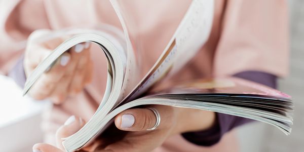 Close-up of person flipping through a magazine.