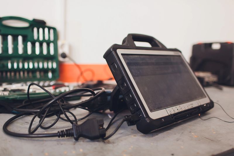 car mechanic maintains a vehicle with the help of a diagnostic computer - modern technology in the car repair shop