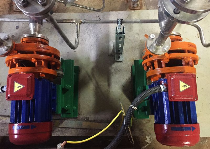 Pump and engine at an industrial facility. Caution the equipment in action. Details and close-up.