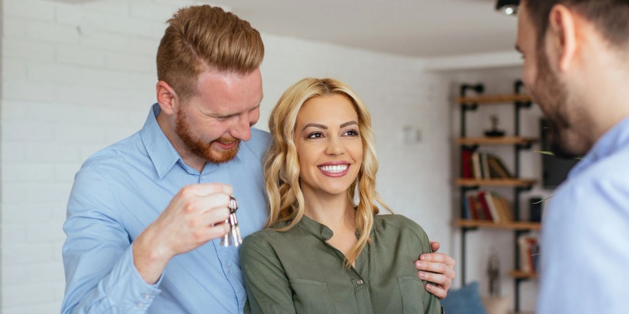 Happy couple receiving keys to their new home.
