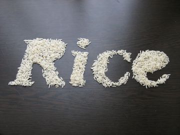 The word 'Rice' spelled out using grains of rice on a dark surface.