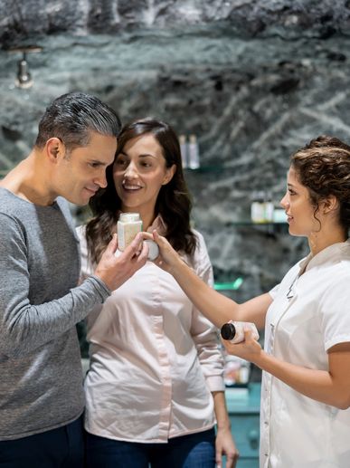 A couple consulting a pharmacist about a product in a modern pharmacy.