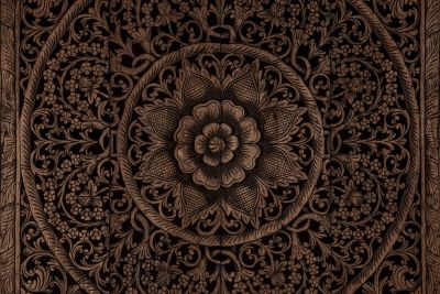 Intricate floral wood carving with detailed patterns.