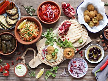 Traditional Middle Eastern mezze with falafel, hummus, tabbouleh, pita, and olives.