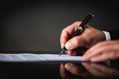 Hand signing a formal legal notice with a pen