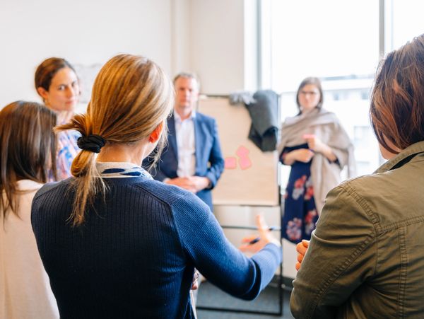 People engaged in a group discussion in a bright office room.