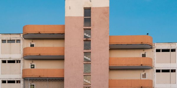 Symmetrical view of a beige and orange building under a clear blue sky.