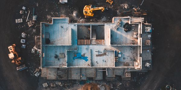 Aerial view of a construction site with building foundation and machinery.