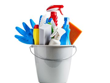 A white bucket filled with various colorful cleaning supplies and gloves.