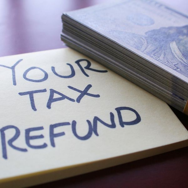 Stack of money beside a note saying 'Your Tax Refund'.