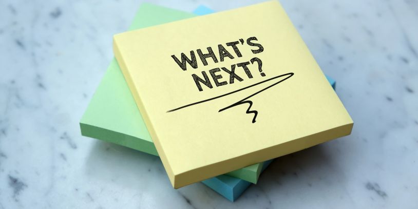 Sticky note saying "WHAT'S NEXT?" on a stack of pastel notes.