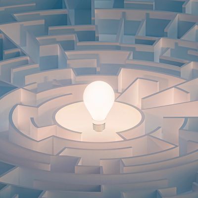 Glowing light bulb in the center of a maze.