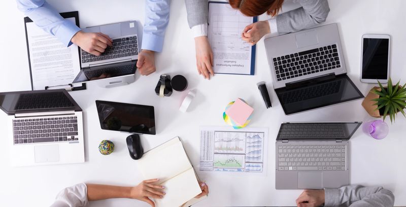 Overhead View Of A Businesspeople At Table With Laptops Having Discussion In The Meeting