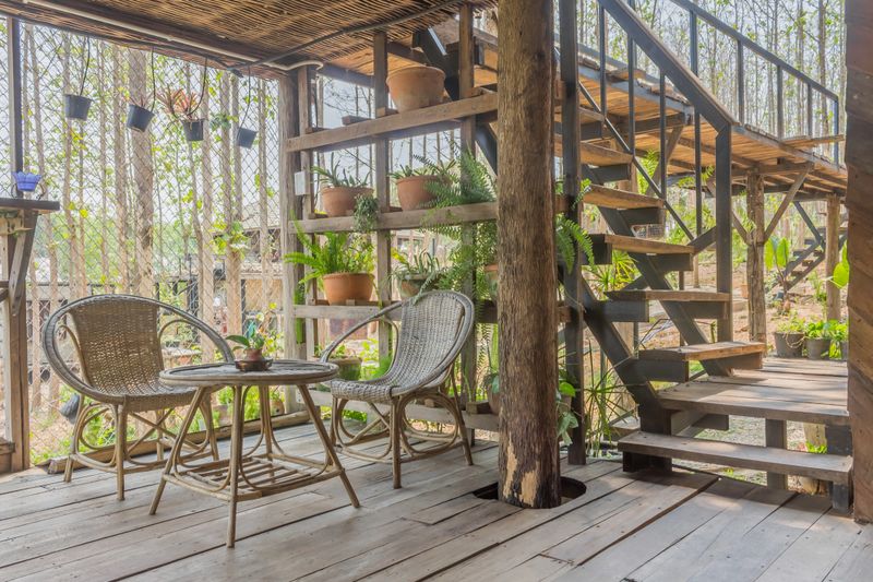 Interior Design Room of Home Stay with Rattan Chair and Table and Tree and Stair. Interior design room at floor 1 with tree and plants. Living room interior design in classic style