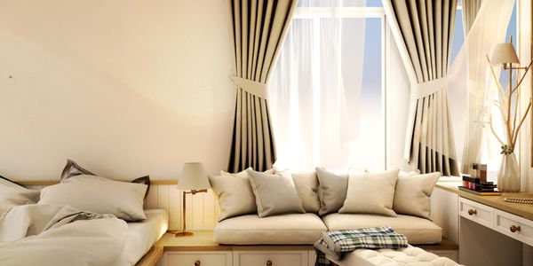 Cozy bedroom with beige tones and natural light from large window.