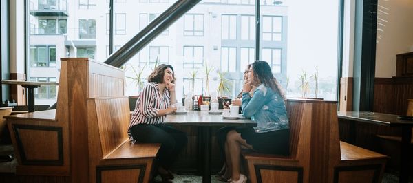 Busy restaurant filled with patrons enjoying meals and conversations.