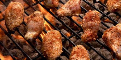 Chicken wings grilling over an open flame.