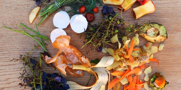A collection of various fruit and vegetable scraps on a wooden surface.