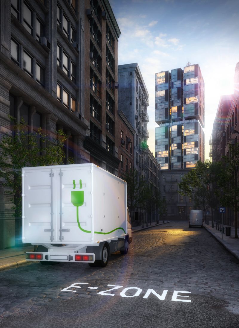 electric truck in electric cars only zone with highrise in the background